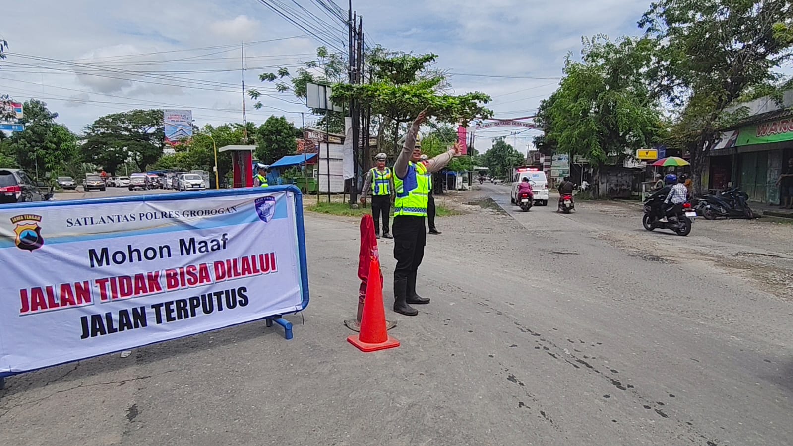 DIALIHKAN &ndash; Anggota Satlantas Polres Grobogan lakukan pengaturan jalan di Pertigaan Gubug arah Kemiri Jeketro untuk kendaraan dialihkan ke Jalan Alternatif karena jalan Purwodadi &ndash; Semarang putus gak