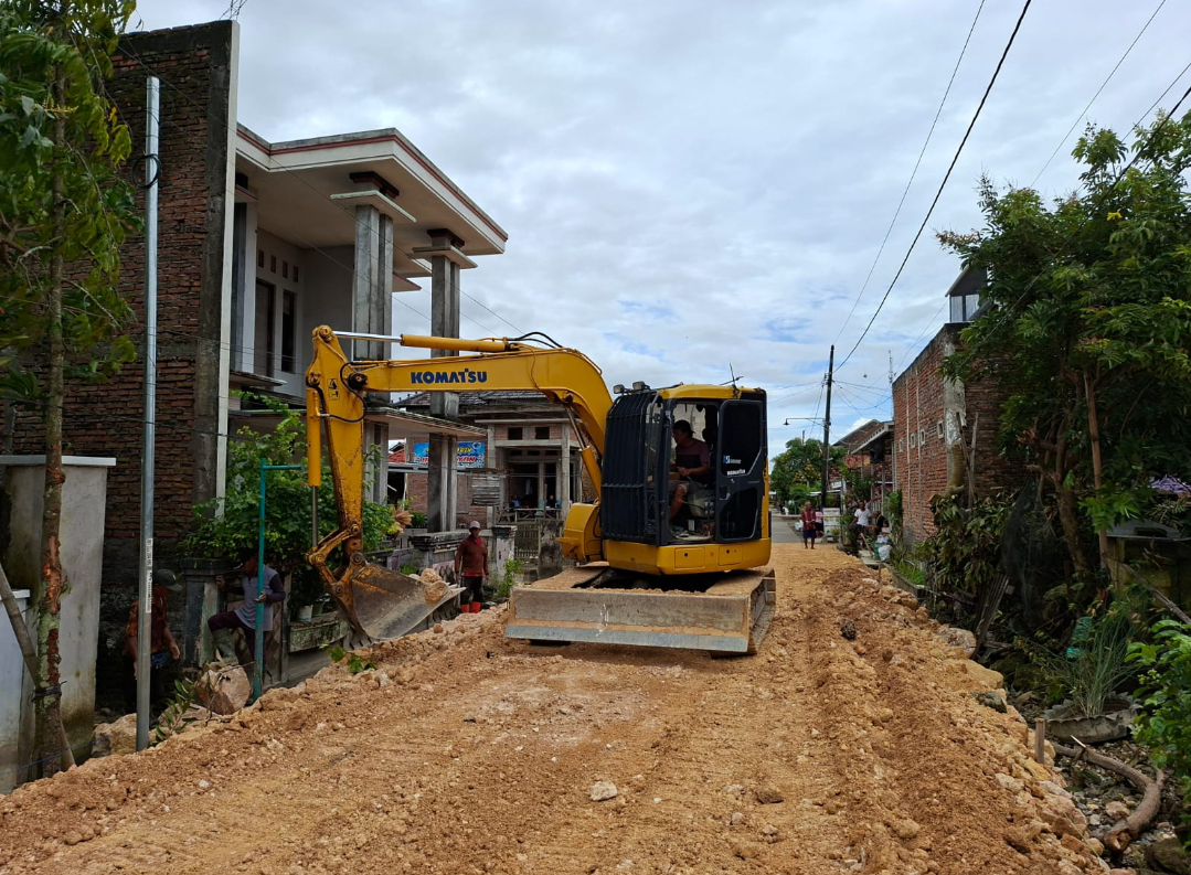 PROSES: Petugas mengoperasikan alat berat guna membantu meratakan batu kapur untuk peninggian jalan di Dukuh Krajan, Karangrowo, Selasa (17/2). (ANDIKA TRISNA SAPUTRA/RADAR KUDUS)