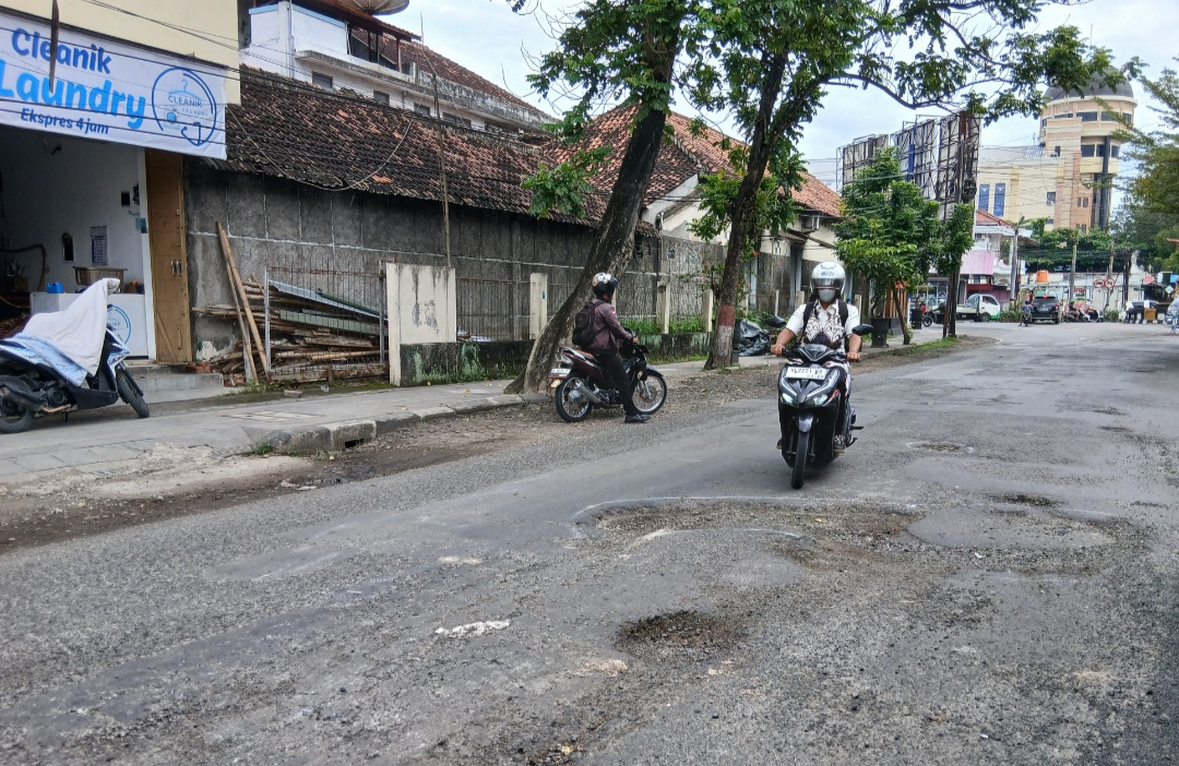 PARAH: Pengendara berhati-hati saat melintas di Jalan Gunandar menghindari lubang.