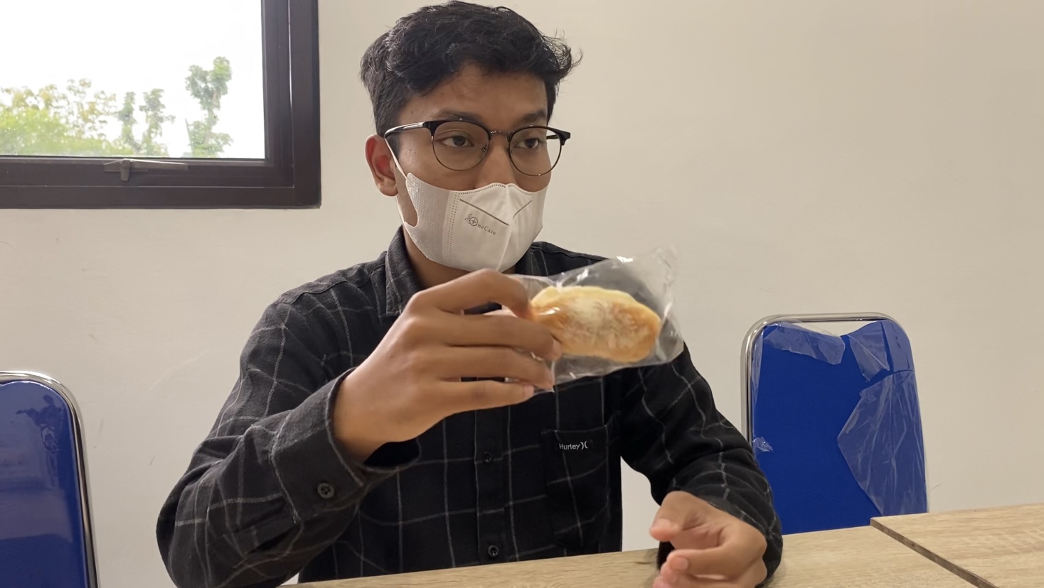 MEMEGANG SAMPEL: Kepala SPPG yayasan as Sanusiyyah menunjukkan roti MBG yang didistribusikan kepada penerima manfaat edisi Ramadan.