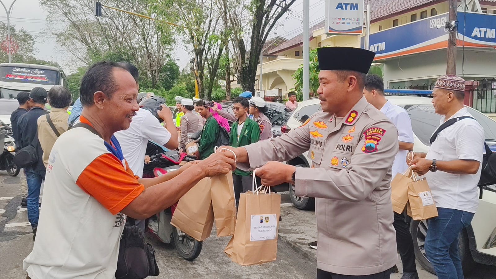 BERBAGI &ndash; Kapolres Grobogan AKBP Ike Yulianto bersama awak media dan mahasiswa membagikan takjil di bulan Ramadhan depan Mapolres setempat, Rabu (25/2).