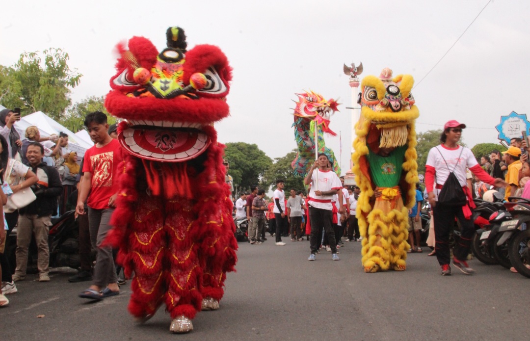 MERIAH: Pemain barongsai memukau warga dalam Festival Imlek pada Rabu (25/2).