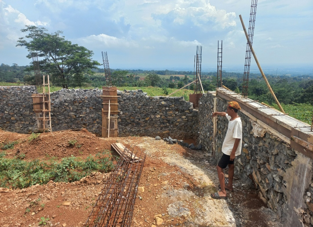 MANDEK: Warga Desa Bandung Kecamatan Mayong, Wawan menunjukkan pembangunan gedung Koperasi Desa Merah Putih yang terhenti pada Kamis (26/2).