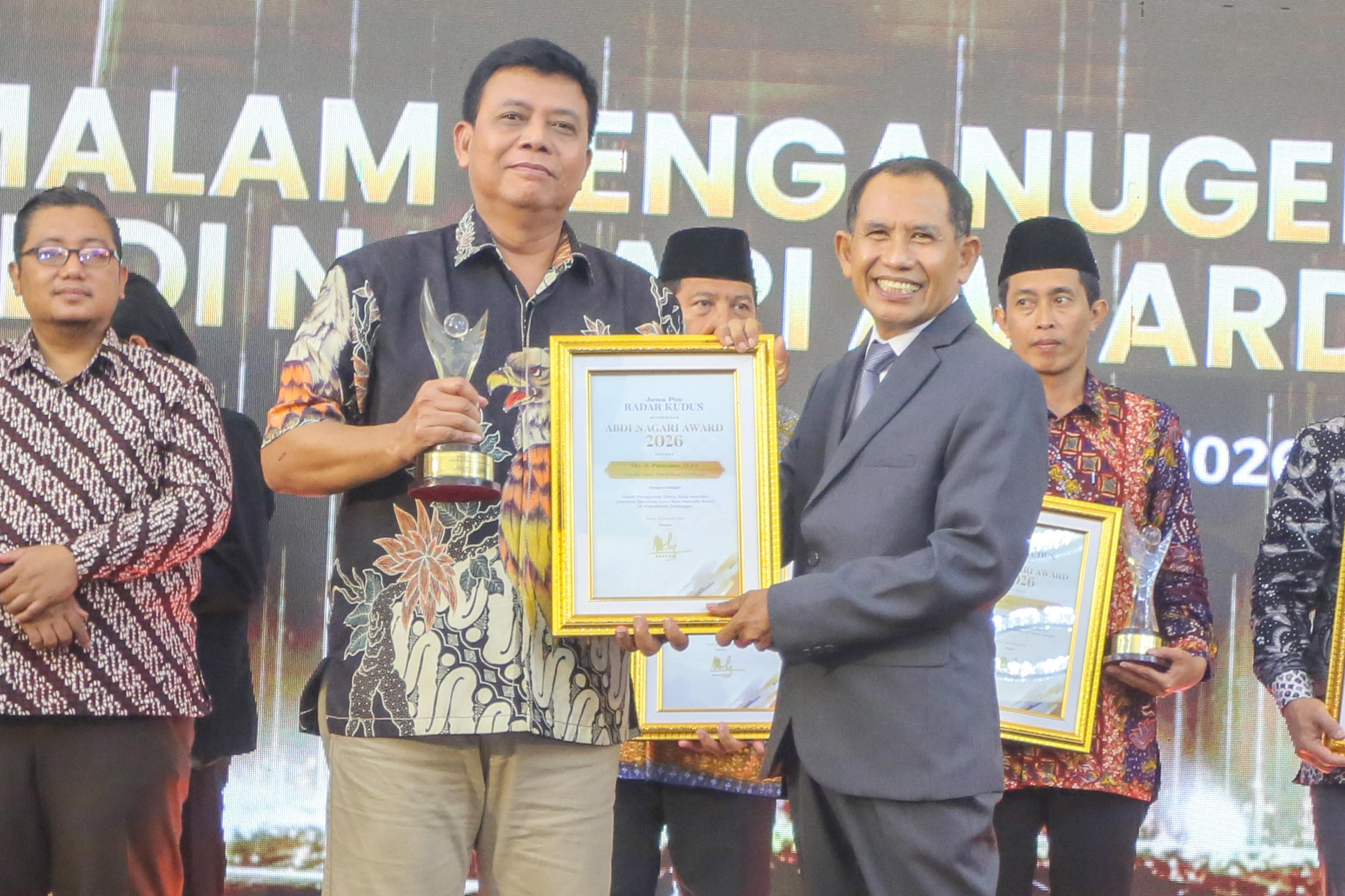 PRESTASI &ndash; Kepala Dinas Pendidikan Grobogan Purnyomo menerima penghargaan Abdi Nagari Award dari Direktur Radar Kudus Baehaqi. 
