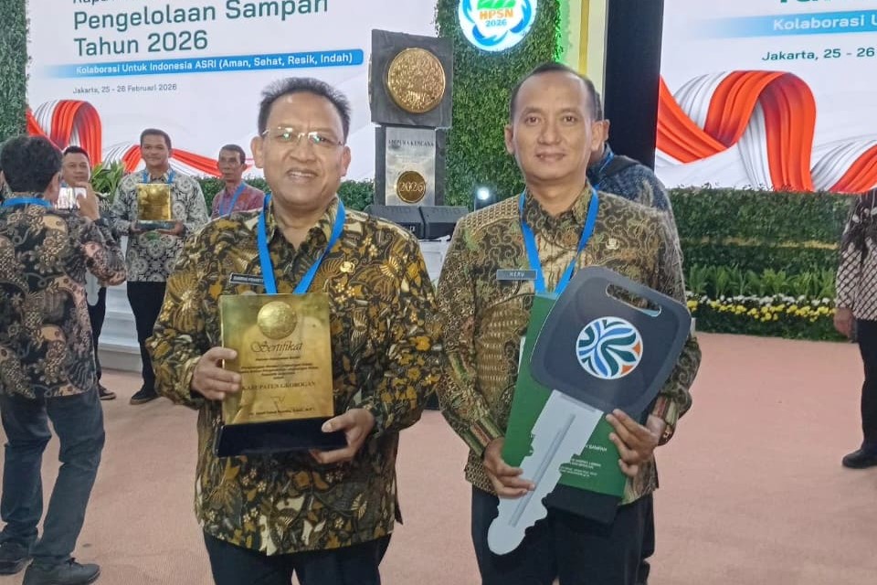 PENGHARGAAN: Bupati Grobogan Sugeng Prasetyo dan Kepala DLH Heru Dwi Cahyono saat menerima penghargaan dan tiga unit sepeda pengangkut sampah.