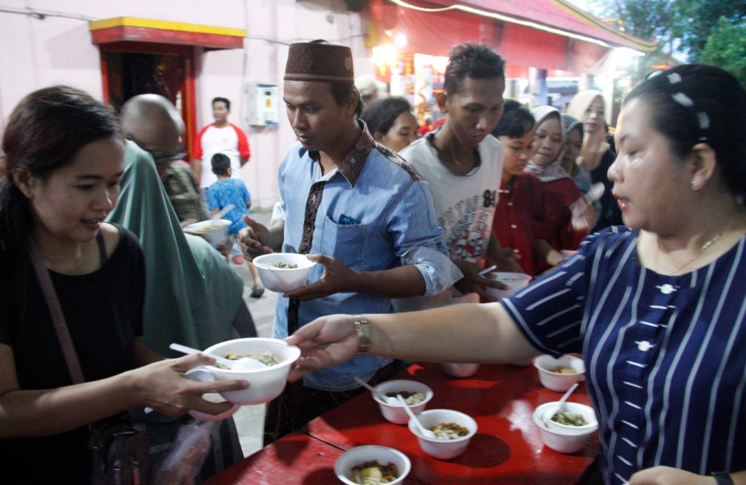 BUKA BERSAMA: Warga menyerbu lontong Cap Go Meh yang disajikan pengurus di Kelenteng Welahan.