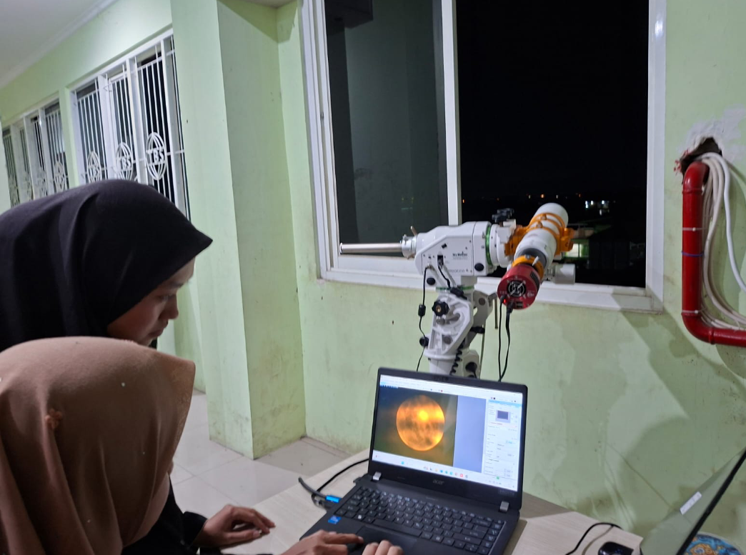 AMATI: Salah satu peserta putri mengamati proses gerhana bulan total melalui teleskop yang terhubung dengan laptop di GSG TBS Kudus lantai 5, Selasa (3/3). (ANDIKA TRISNA SAPUTRA/RADAR KUDUS)
