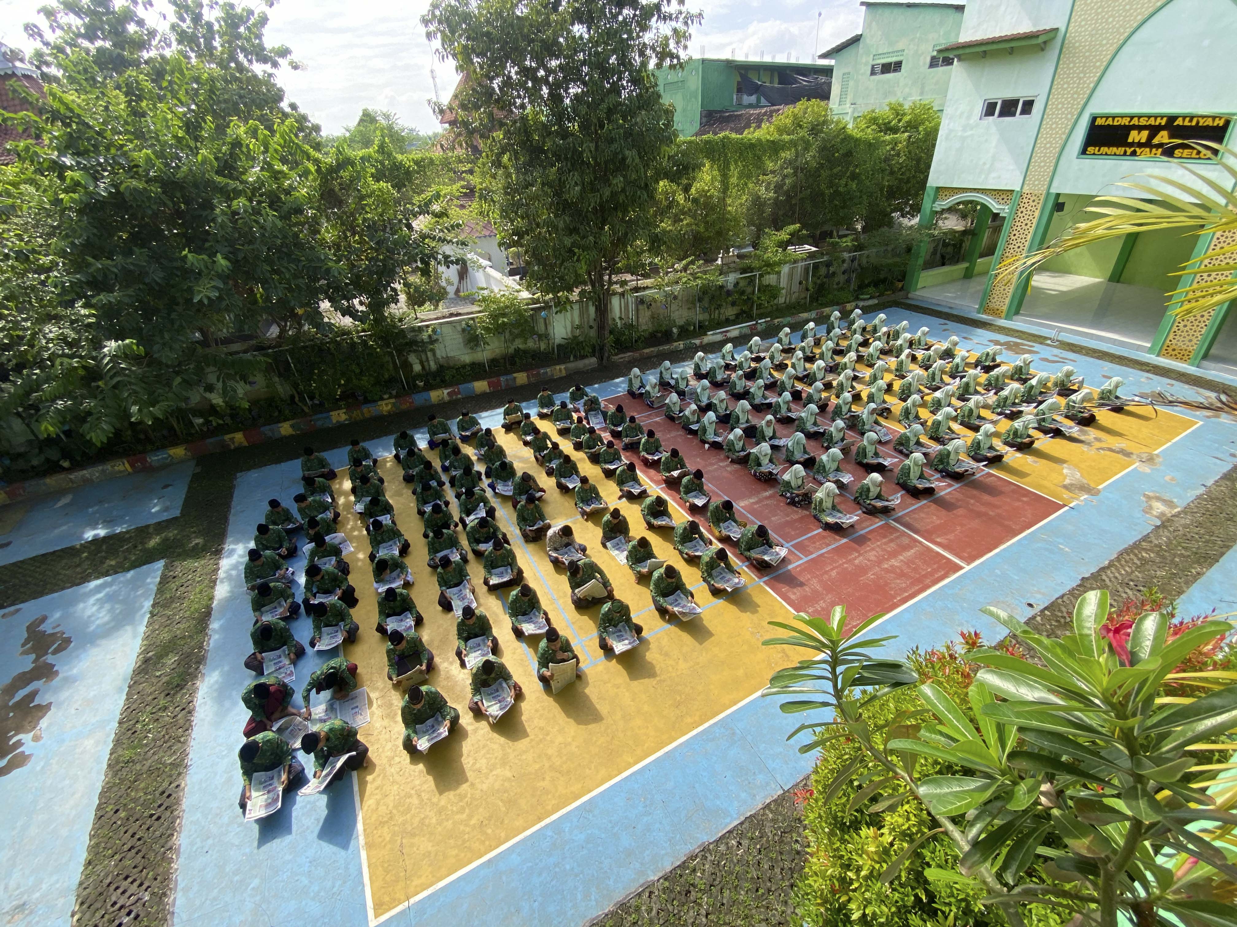 LITERASI: Ratusan siswa MA Sunniyyah Selo, Tawangharjo, Grobogan membaca koran Jawa Pos Radar Kudus di lapangan madrasah dalam kegiatan Gerakan Literasi Madrasah.