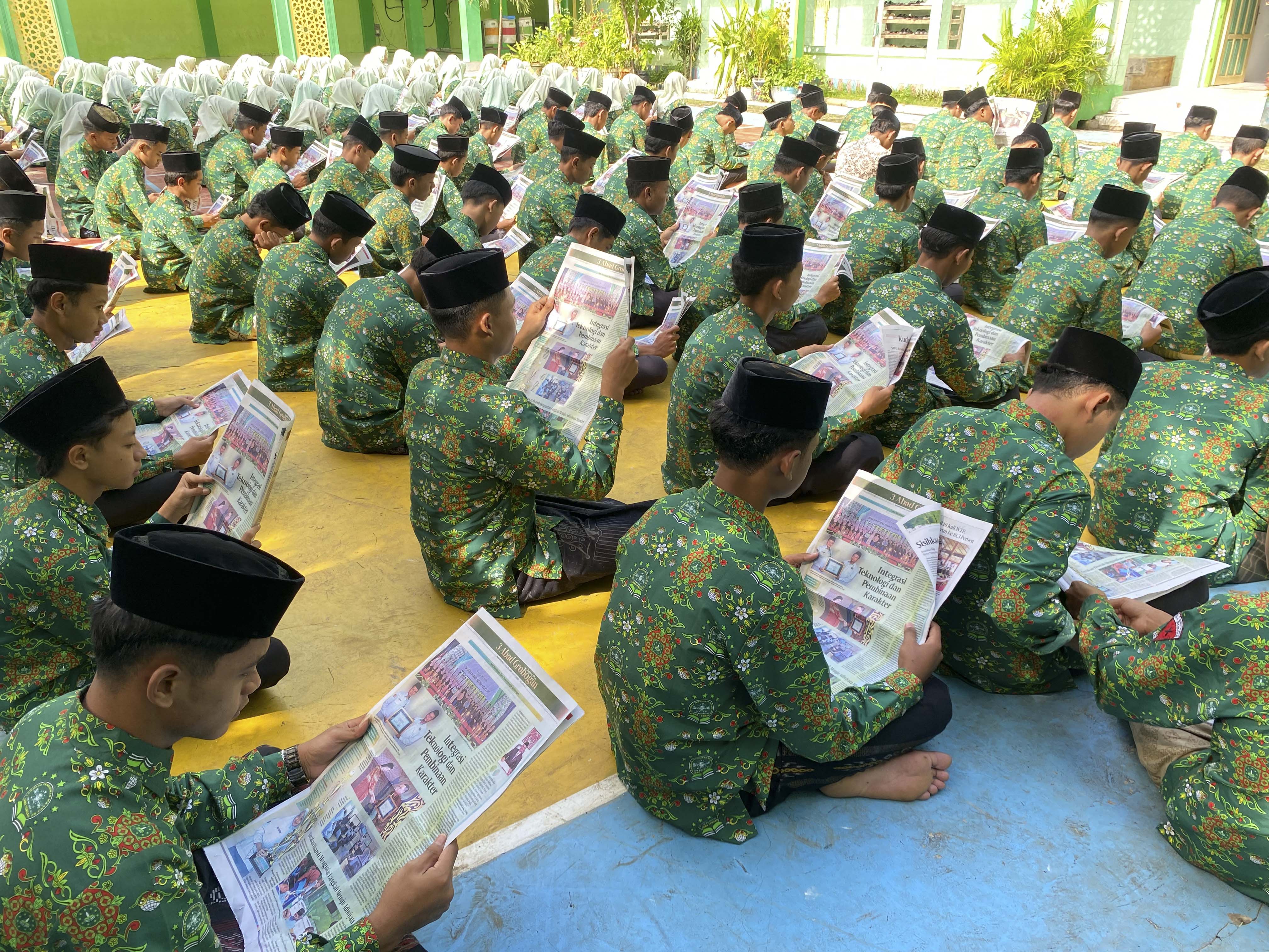 KEREN: Ratusan siswa MA Sunniyyah Selo serempak membaca koran Jawa Pos Radar Kudus.