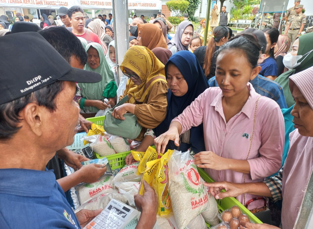 LEBIH MURAH: Warga tengah membeli sembako di pasar murah yang digelar di halaman Kejari Jepara pada Senin (9/2).