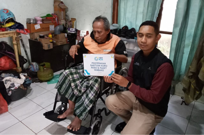 Penyerahan bantuan kursi roda kepada Abdul Azis, oleh YBM PLN UIK Tanjung Jati B.
