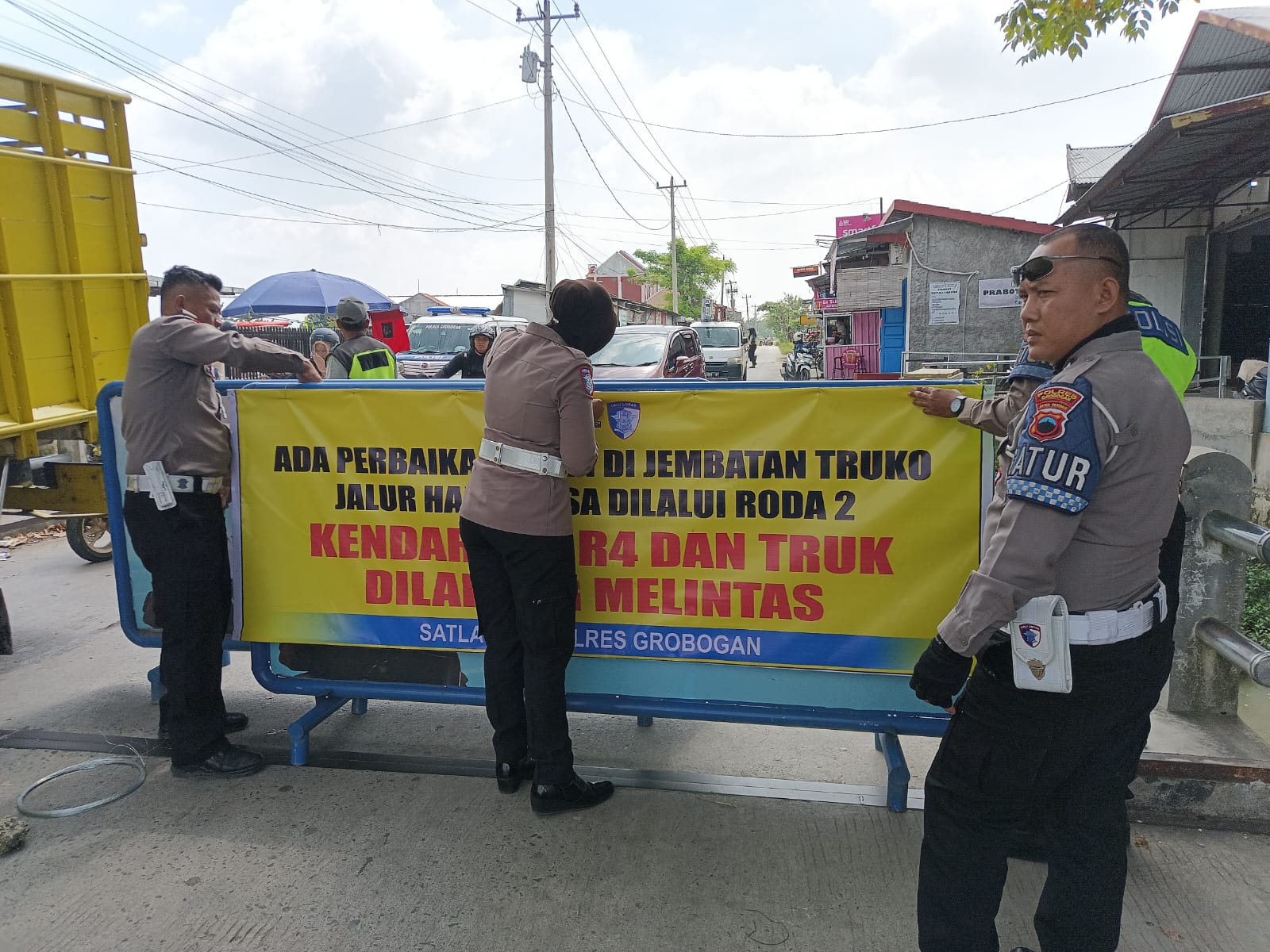 PENGALIHAN JALUR: Satlantas Polres Grobogan saat memasang banner pengalihan jalur alternatif. 
