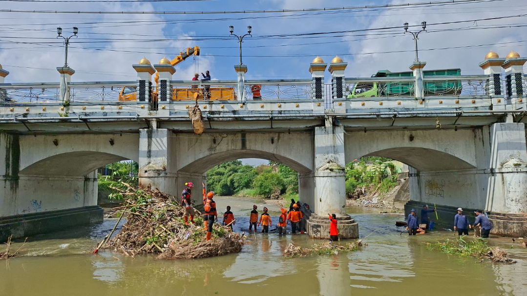 BERSIH-BERSIH: Tim gabungan berkolaborasi membersihkan sampah yang tersangkut di pilar jembatan Sungai Gelis, Rabu (11/3). (ANDIKA TRISNA SAPUTRA/RADAR KUDUS)