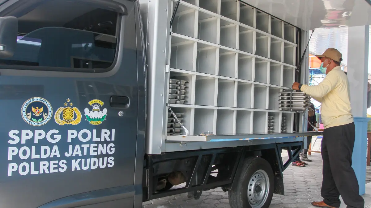 DIKEMAS: Petugas SPPG Polres Kudus memasukan kotak MBG ke dalam mobil untuk didistribusikan ke sekolah.