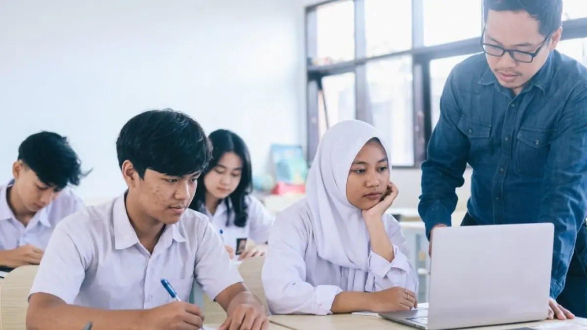 Ilustrasi guru membimbing siswa saat pelajaran