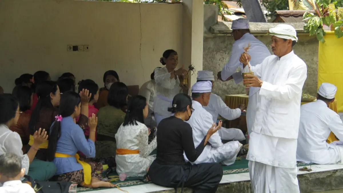 KHIDMAT: Pemangku tengah mencipratkan tirta suci kepada umat saat sembahyang bersama mecaru di Pura Puser Bumi Desa Plajan, Kecamatan Pakis Aji pada Rabu (18/3). (FIKRI THOHARUDIN/RADAR KUDUS)