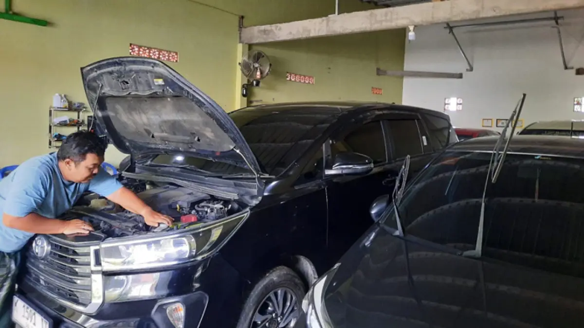 CEK MESIN MOBIL: Pemilik rental mobil Deni Eko Mulyono saat melakukan cek up mobil yang akan dibawa customer untuk Lebaran baru-baru ini. (INDAH SUSANTI/RADAR KUDUS)
