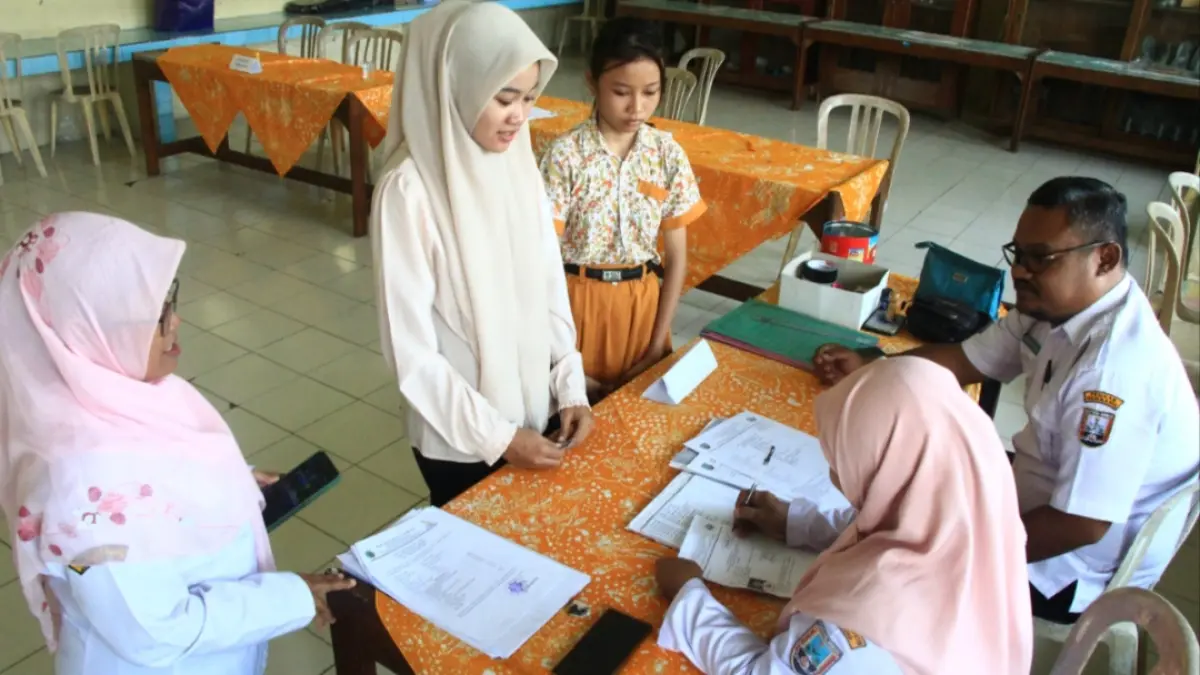 SERAHKAN BERKAS: Calon siswa baru SMPN 4 Rembang kumpulkan berkas pendaftaran tahun 2025 didampingi wali murid. (WISNU AJI/RADAR KUDUS) 