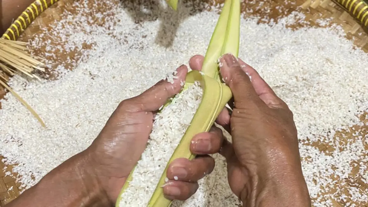 TELATEN: Proses pengisian lepet.