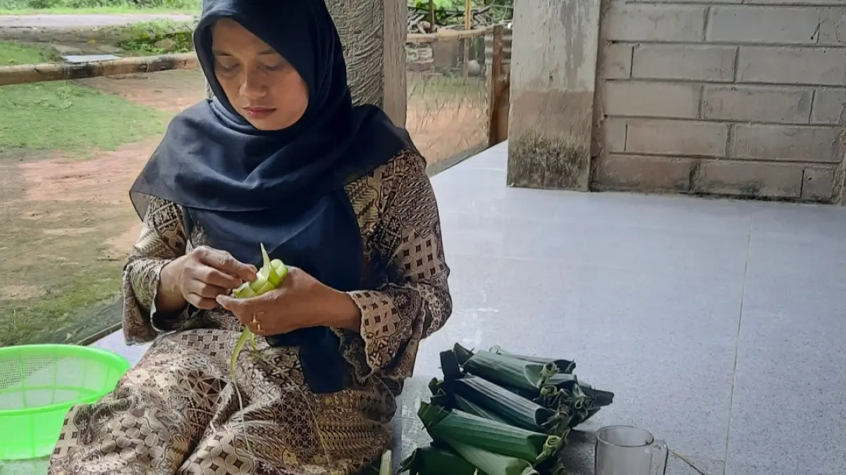 TELATEN: Warga Desa Kemujan tengah membuat kupat dan lepet untuk Bodo Kupat pada Sabtu (28/3) mendatang. (SOFI