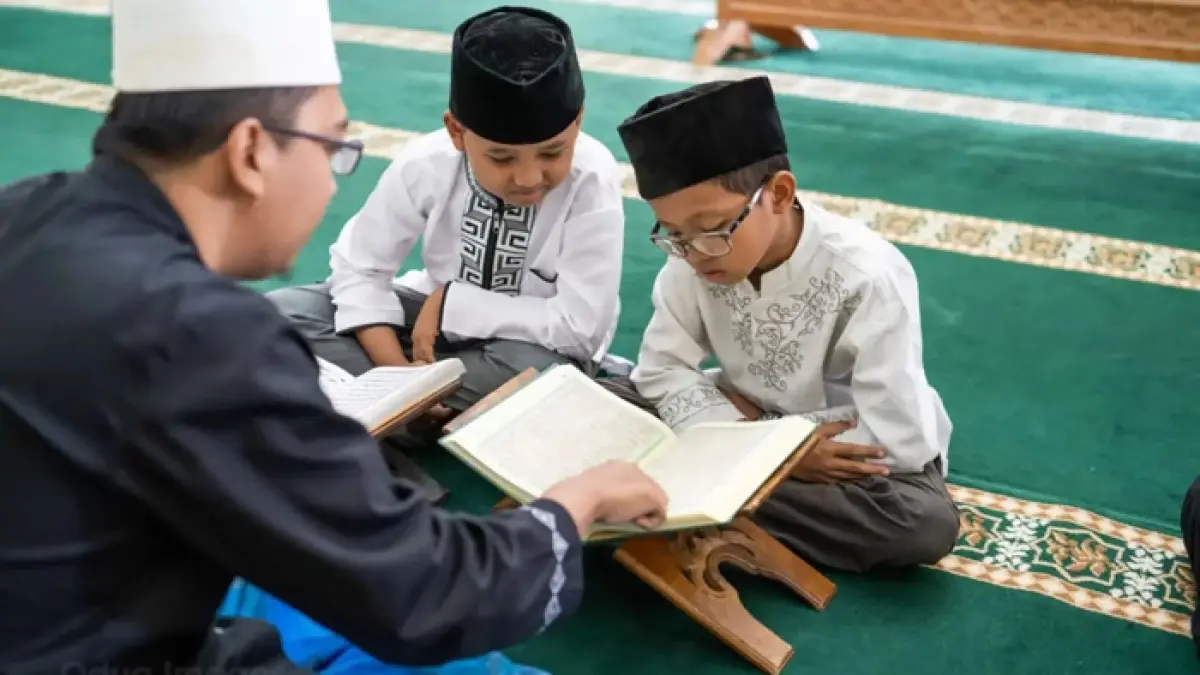 Seorang guru sedang mengajar membaca Al-Qur