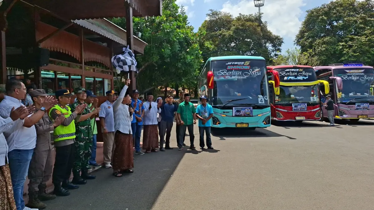 BERANGKAT: Bupati Kudus, Sam’ani Intakoris mengibarkan bendera sebagai simbolis keberangkatan bus Balik Rantau Gratis di Pendapa Kabupaten Kudus, Sabtu (28/3). (ANDIKA TRISNA SAPUTRA/RADAR KUDUS)
