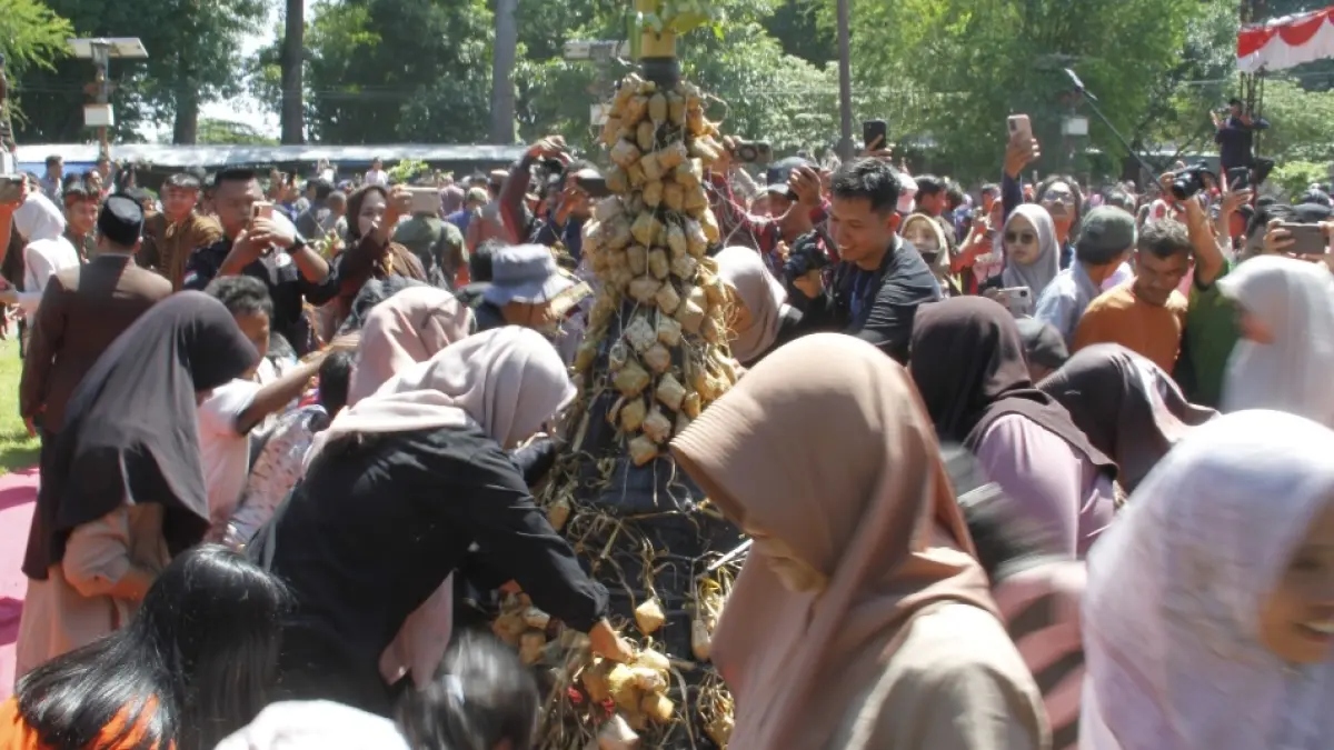 BERHARAP BERKAH: Para warga merebutkan kupat dan lepet. (FIKRI THOHARUDIN/RADAR KUDUS)