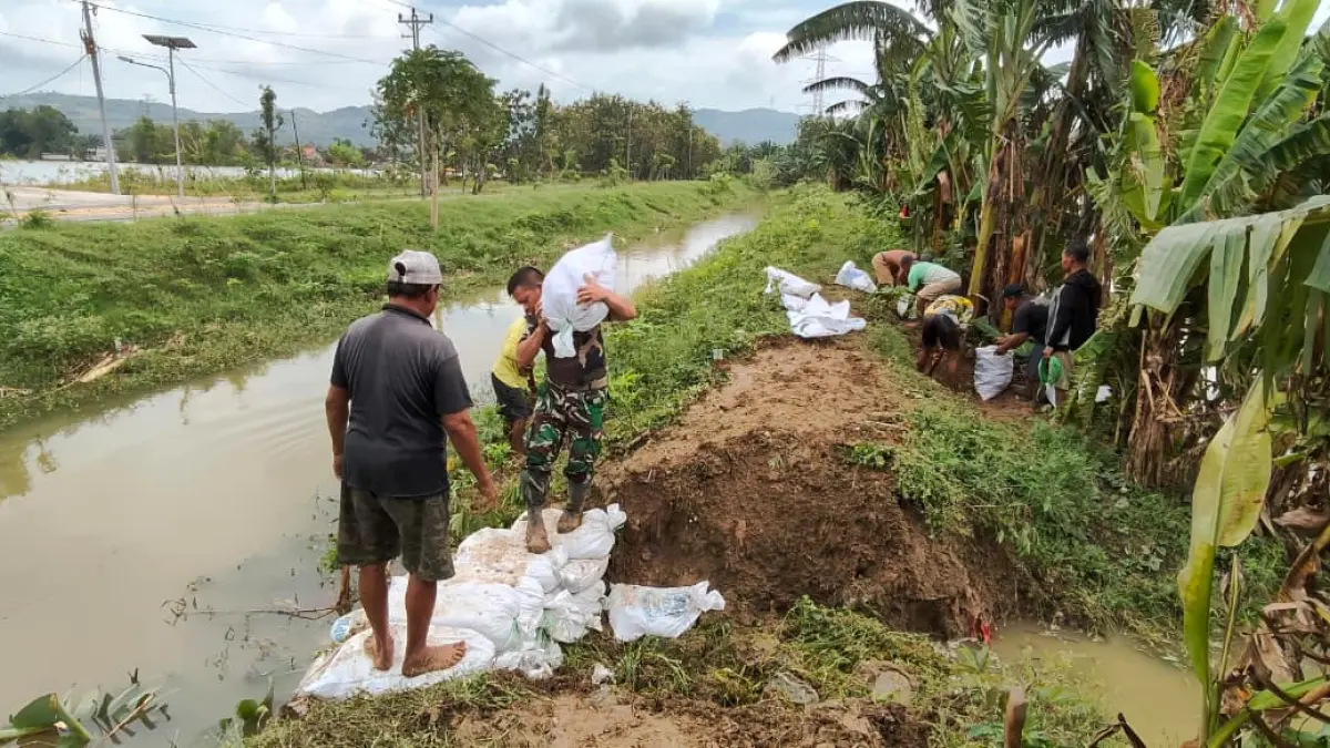 DARURAT: Babinsa Karangsari Koramil 13/Brati saat membantu penanganan perbaikan tanggul jebol di Desa Karangsari Kecamatan Brati. (Pendim 0717/Grobogan untuk Radar Kudus)