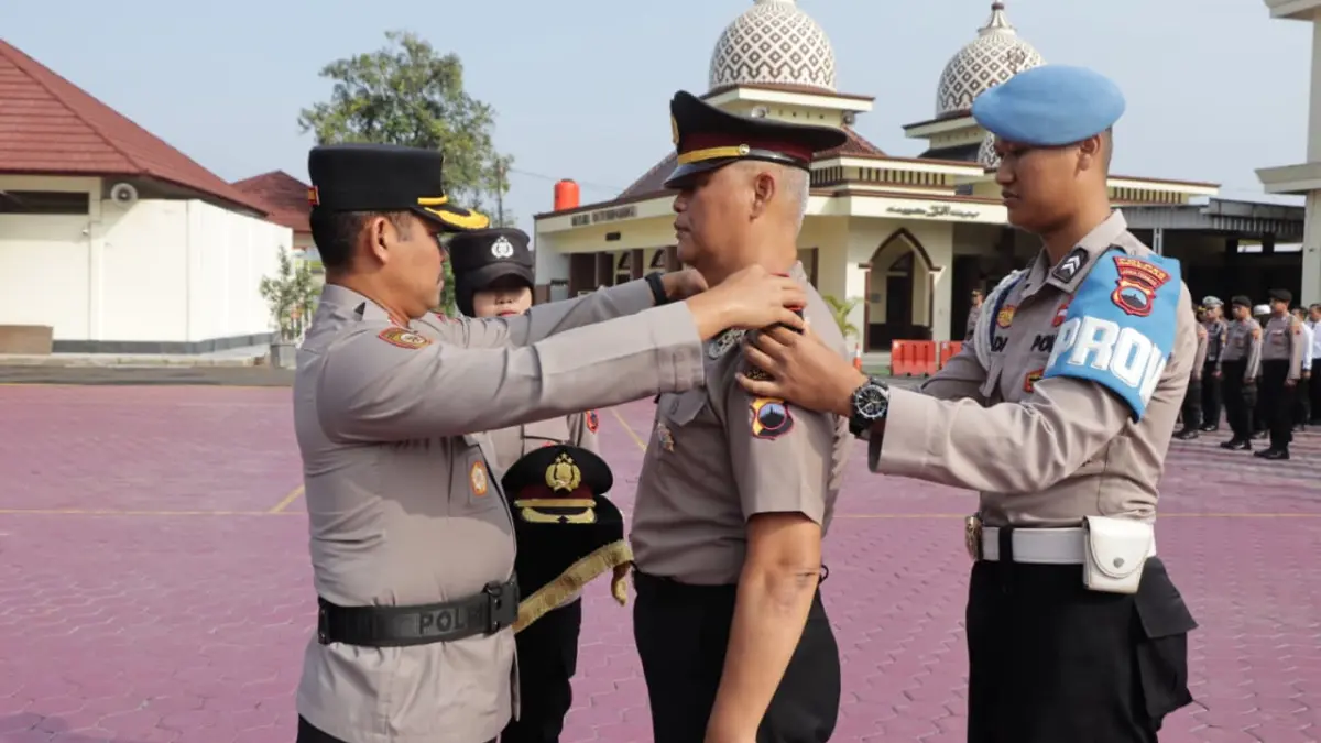 NAIK JABATAN – Kapolres Grobogan AKBP Ike Yulianto memasang tanda kenaikan pangkat Kompol pada Kapolsek Ngaringan Kompol Mujiyadari di halaman Mapolres setempat, Senin (30/3). 