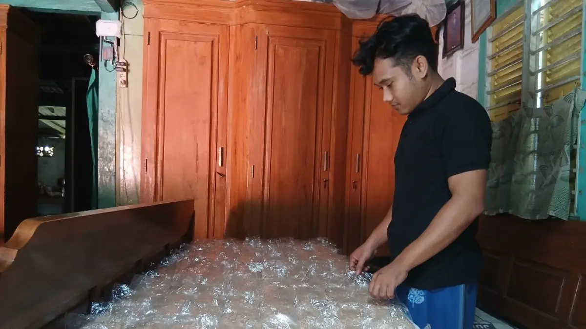 CARI AKAL: Najib Nur Roihan saat menata tempe yang belum matang. (EKO SANTOSO/RADAR KUDUS)