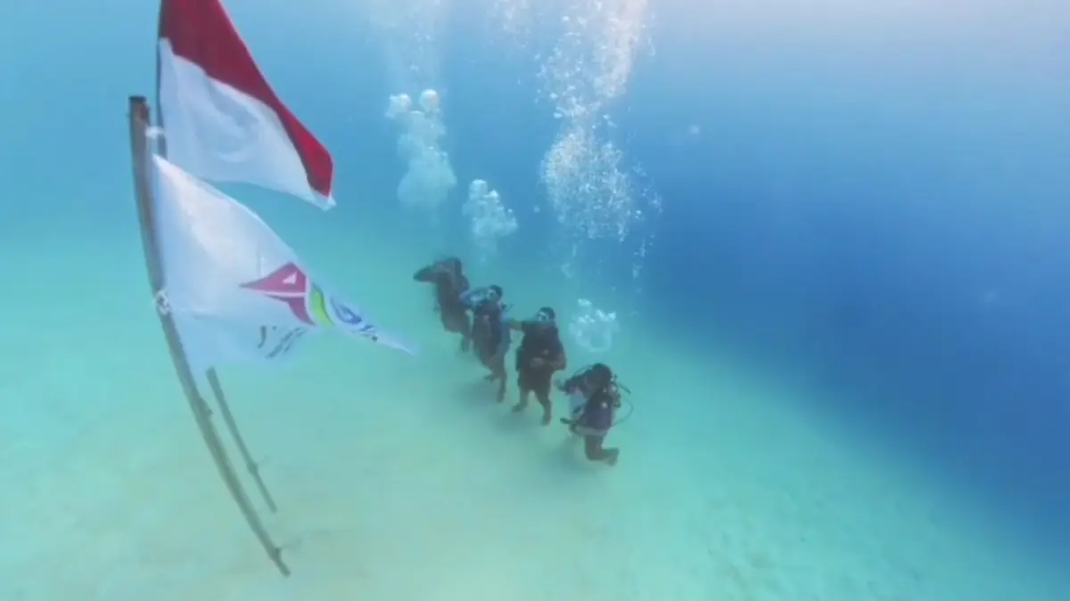 KHIDMAT: Prosesi pengibaran bendera merah putih dalam rangka Hari Jadi ke-477 Jepara pada Kamis (9/4). Pengibaran dilakukan di laut Pulau Menjangan Kecil. (PAGUYUBAN GUIDE DIVING UNTUK RADAR KUDUS)