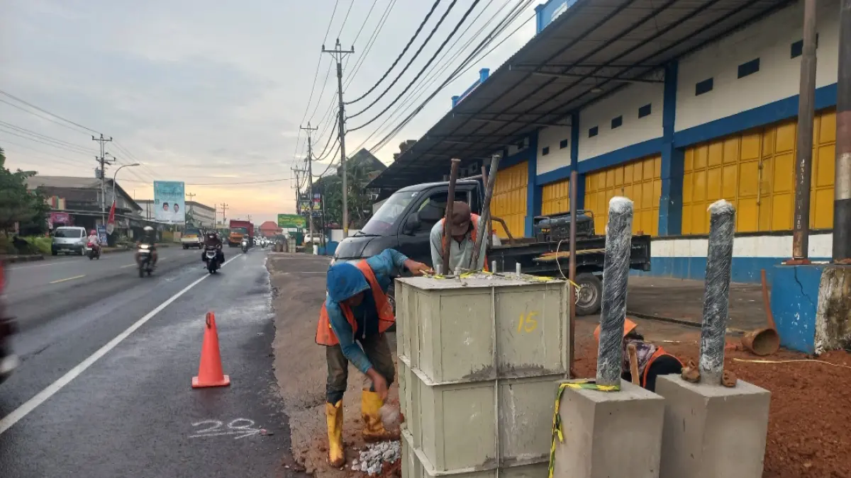 TAMBAH PENERANGAN: Pekerja tengah membuat pondai untuk penerangan jalan umum (PJU) di Jalan Raya Jepara-Kudus di Ruas Pecangaan.&nbsp;(FIKRI THOHARUDIN/RADAR KUDUS)