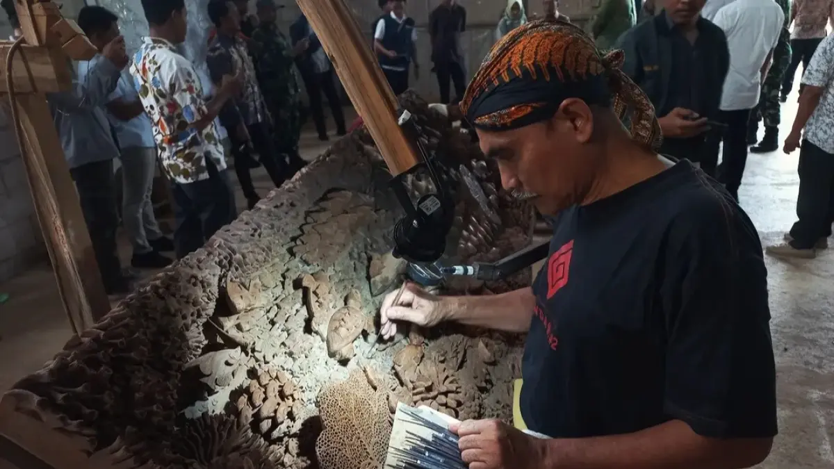 TELATEN: Hartono Kasari salah satu seniman yang terlibat dalam Pameran Tatah tengah membuat detail karyanya. (FIKRI THOHARUDIN/RADAR KUDUS)