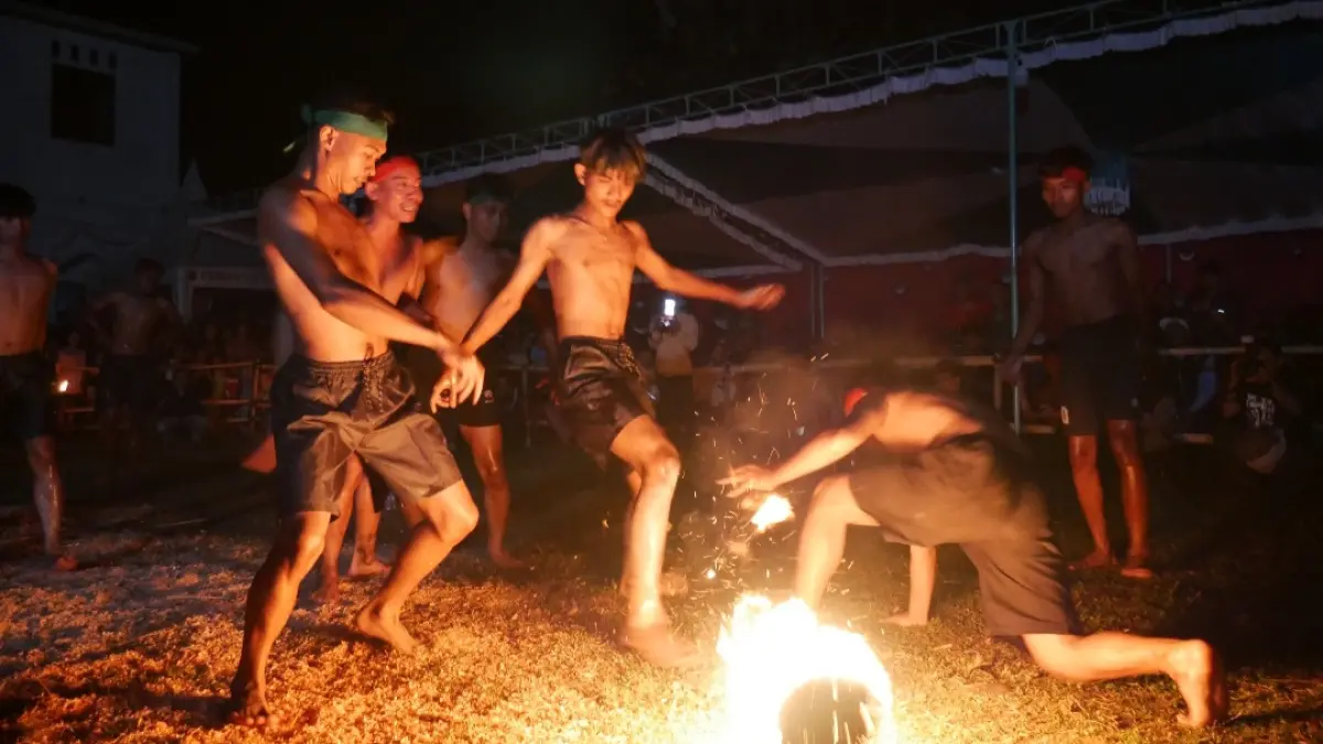 MENGHIBUR: Para pemain sepakbola api tengah menampilkan atraksi wisata pada Selasa (21/4) malam, di Lapangan Balai Desa Kawak, Pakis Aji, Jepara. (FIKRI THOHARUDIN/RADAR KUDUS)