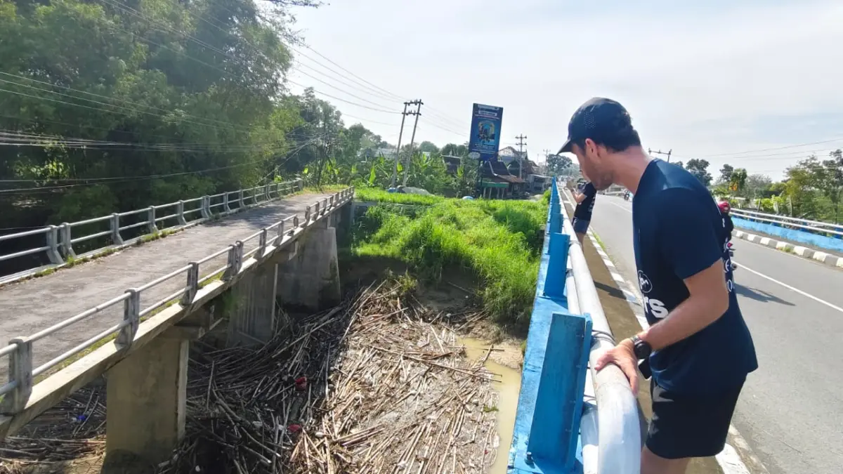 PENUH SAMPAH –  Gary bersama Sam dan Kelly Benchehib melihat tumpukan sampah di Jembatan Gatak, Desa Sembungharjo, Kecamatan Pulokulon dalam perjalan run for rivers, Senin pagi (27/4). 