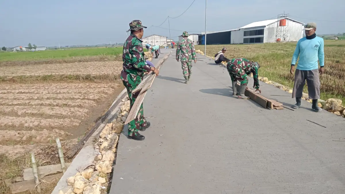 Anggota Satgas TMMD Reguler Kodim Pati bersama warga setempat mengebut pengerjaan betonisasi jalan pertanian Desa Godo Kecamatan Winong. (SATGAS TMMD REGULER KODIM PATI)