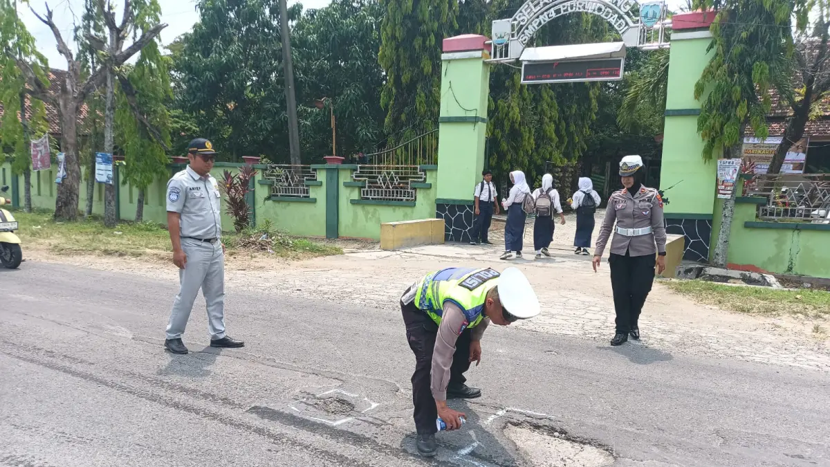 PEDULI: Satlantas Polres Grobogan melakukan penandaan lubang jalan di Ruas Danyang-Kuwu.