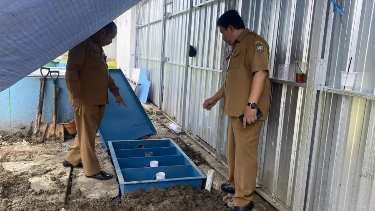 PENGECEKAN: Kepala DLH dan Dinas Kesehatan melihat kondisi IPAL di SPPG Sukorejo 2 yang diduga mencemari lingkungan dengan bau tidak sedap. (ARIF FAKHRIAN KHALIM/RADAR KUDUS)
