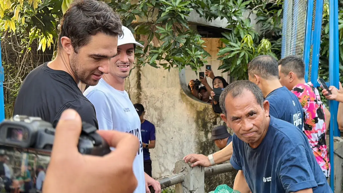 SEMANGAT: Direktur Radar Kudus Baehaqi mengangkat sampah dari sungai.