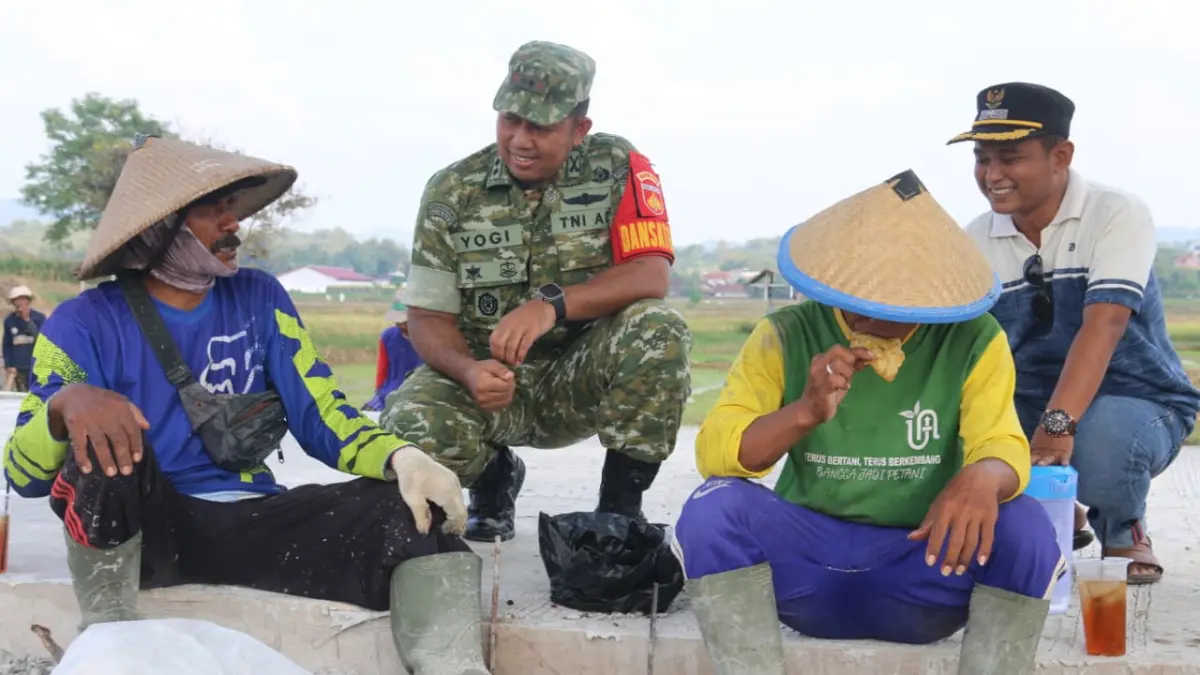 Keakraban Dansatgas TMMD Reguler Kodim Pati Letkol Arm Timotius Yogi bersama warga di sela - sela pekerjaan betonisasi jalan pertanian. (ACHMAD ULIL ALBAB/RADAR KUDUS)