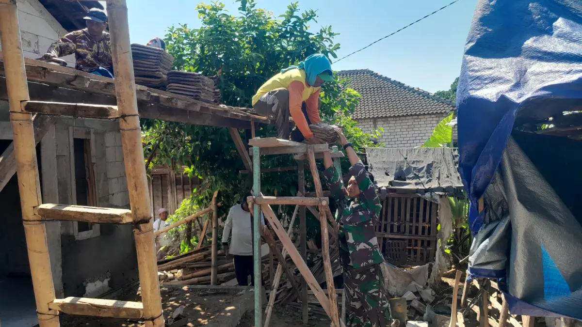 Anggota Satgas TMMD Reguler Kodim Pati bekerjasama dengan masyarakat untuk menyelesaikan renovasi Rumah Tidak Layak Huni (RTLH) di Desa Godo Kecamatan Winong Pati.