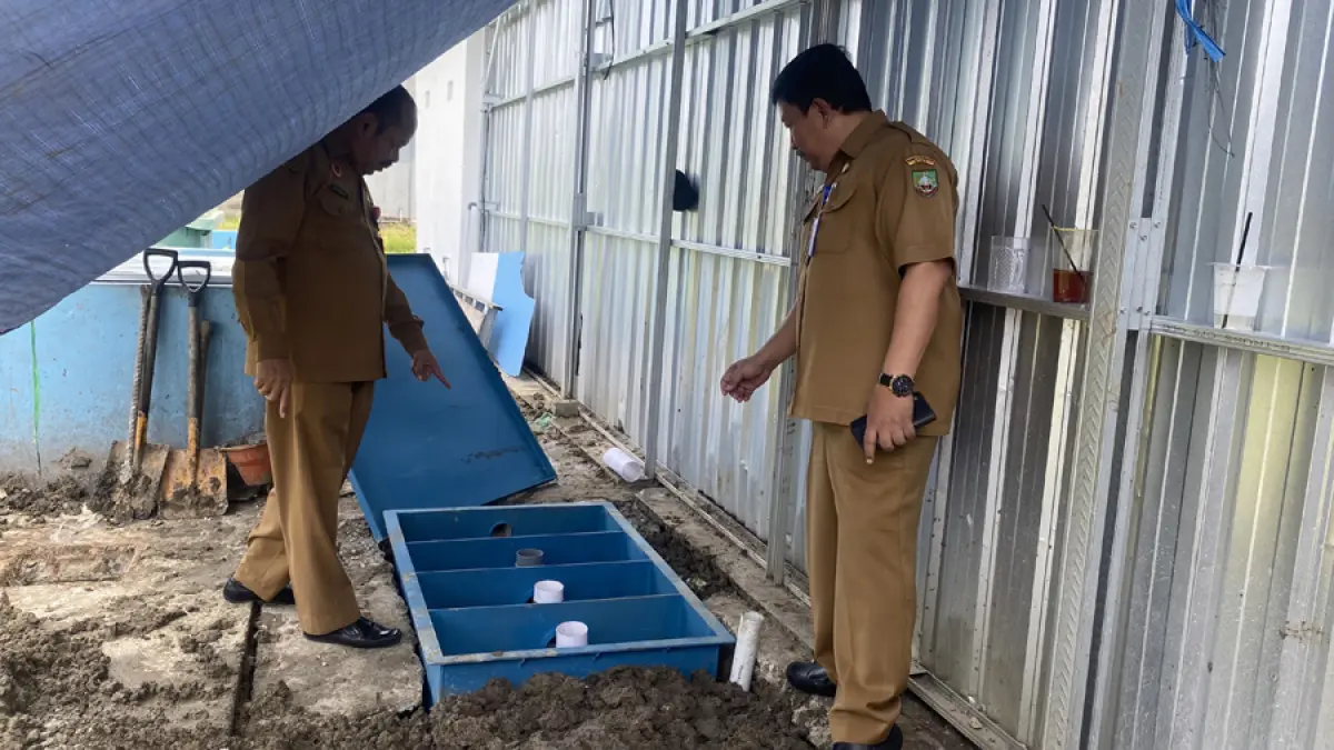 PENGECEKAN: Kepala DLH dan Dinas Kesehatan melihat kondisi IPAL di SPPG Sukorejo 2 yang diduga mencemari lingkungan dengan bau tidak sedap. (ARIF FAKHRIAN KHALIM/RADAR KUDUS)