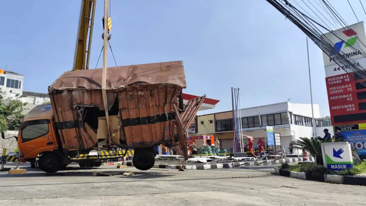 Begini penampakan proses evakuasi truk muatan paket yang terguling menimpa bangunan penyimpan tangki BBM di SPBU Silayur Semarang Rabu (13/5/2026) (Foto Nurchamim Jawa Pos Radar Semarang)