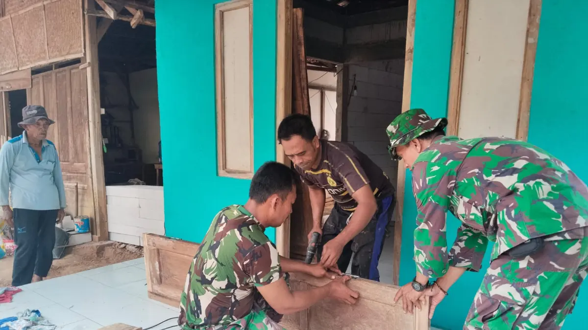 Satgas TMMD Reguler Kodim Pati memasang pintu setelah renovasi RTLH rampung 100 persen. (SATGAS TMMD KODIM PATI)