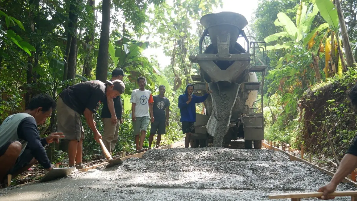 PEDULI: Proses pengecoran jalan Desa Ngabul didanai oleh pengusaha sukses, Komang Aryes Huber, pada Kamis (21/5). (FIKRI THOHARUDIN/RADAR KUDUS)