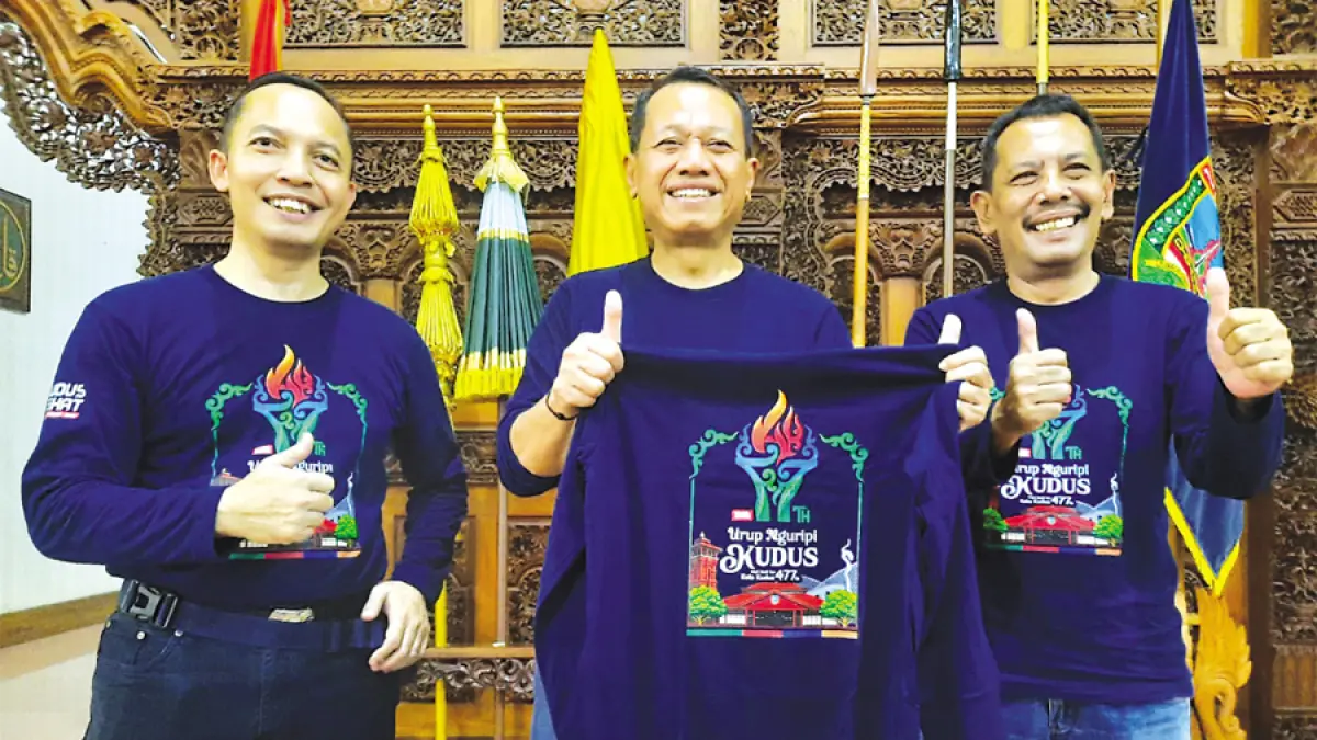 LOGO BARU: Bupati Kudus Sam’ani Intakoris (tengah) memegang kaos dengan gambar Logo Hari Jadi ke 477 Kudus bersama Plh Disbudar Kudus Teguh Riyanto (kiri) dan Sekda Kudus Eko Djumartono (kanan) di Pendapa Kudus. (INDAH SUSANTI/RADAR KUDUS)