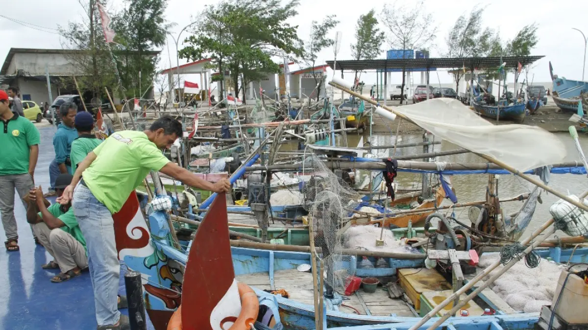 BELUM BEROPERASI: Sejumlah warga tampak wira-wiri di area tambatan perahu nelayan di KNMP Desa Bumiharjo. (FIKRI THOHARUDIN/RADAR KUDUS)&nbsp;