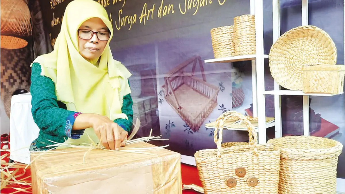 PERAJIN ANYAMAN: Suyati perajin anyaman bambu asal Desa Bulungcangkring, Jekulo menunjukkan kerajinan hasil karyanya. (INDAH SUSANTI/RADAR KUDUS)