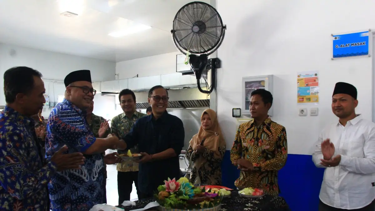 POTONG TUMPENG:Ketua Satgas MBG Kabupaten Rembang Hanies Cholil Barro’ menyerahkan potongan tumpeng kepada  Direktur PT RME Rizal Wijaya saat meluncurkan nyala perdana pengoperasian 
CNG di SPPG Dorokandang, Kecamatan Lasem, kemarin (1/6).
