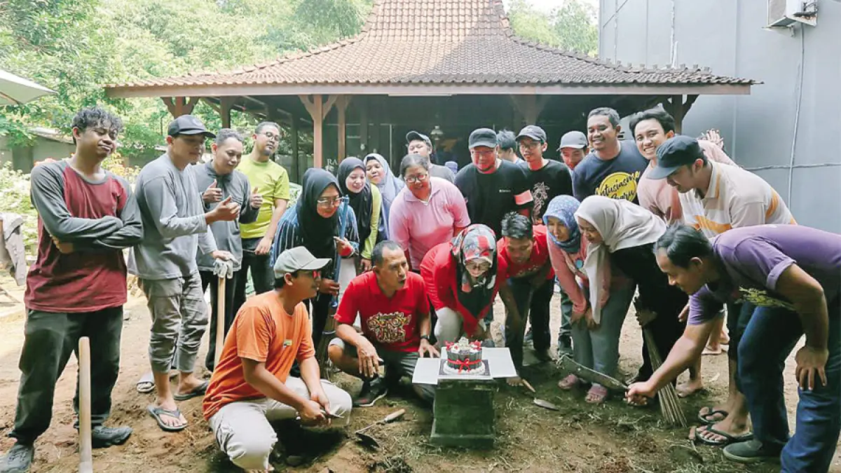 KEBERSAMAAN: Direktur Radar Kudus Baehaqi (tengah) beserta para karyawan meniup lilin kue ulang tahun di sela-sela kerja bakti di halaman belakang kantor Radar Kudus kemarin. (GALIH ERLAMBANG W/RADAR KUDUS)